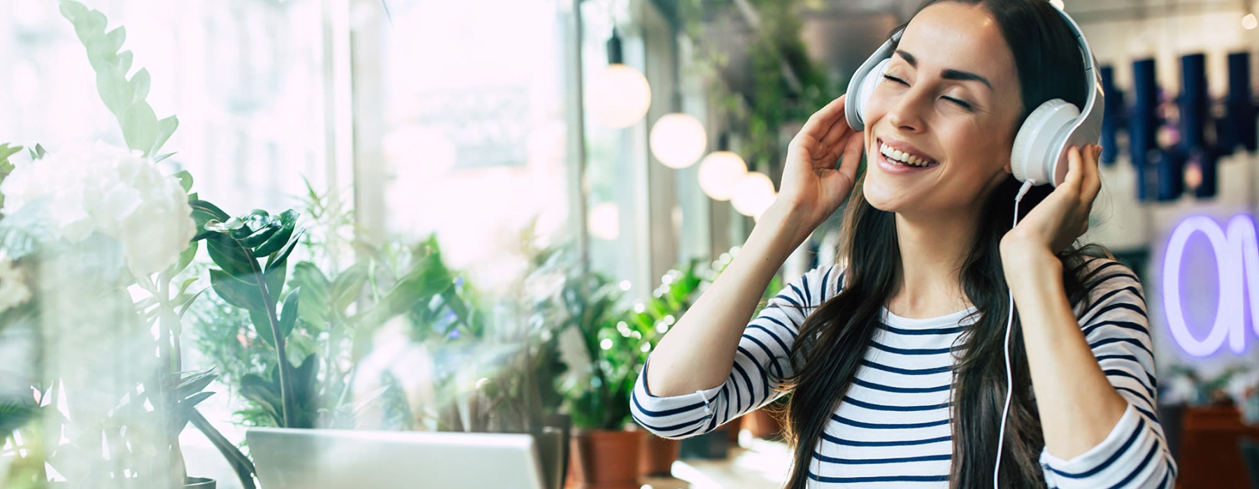 woman with headset on sitting in front of a laptop