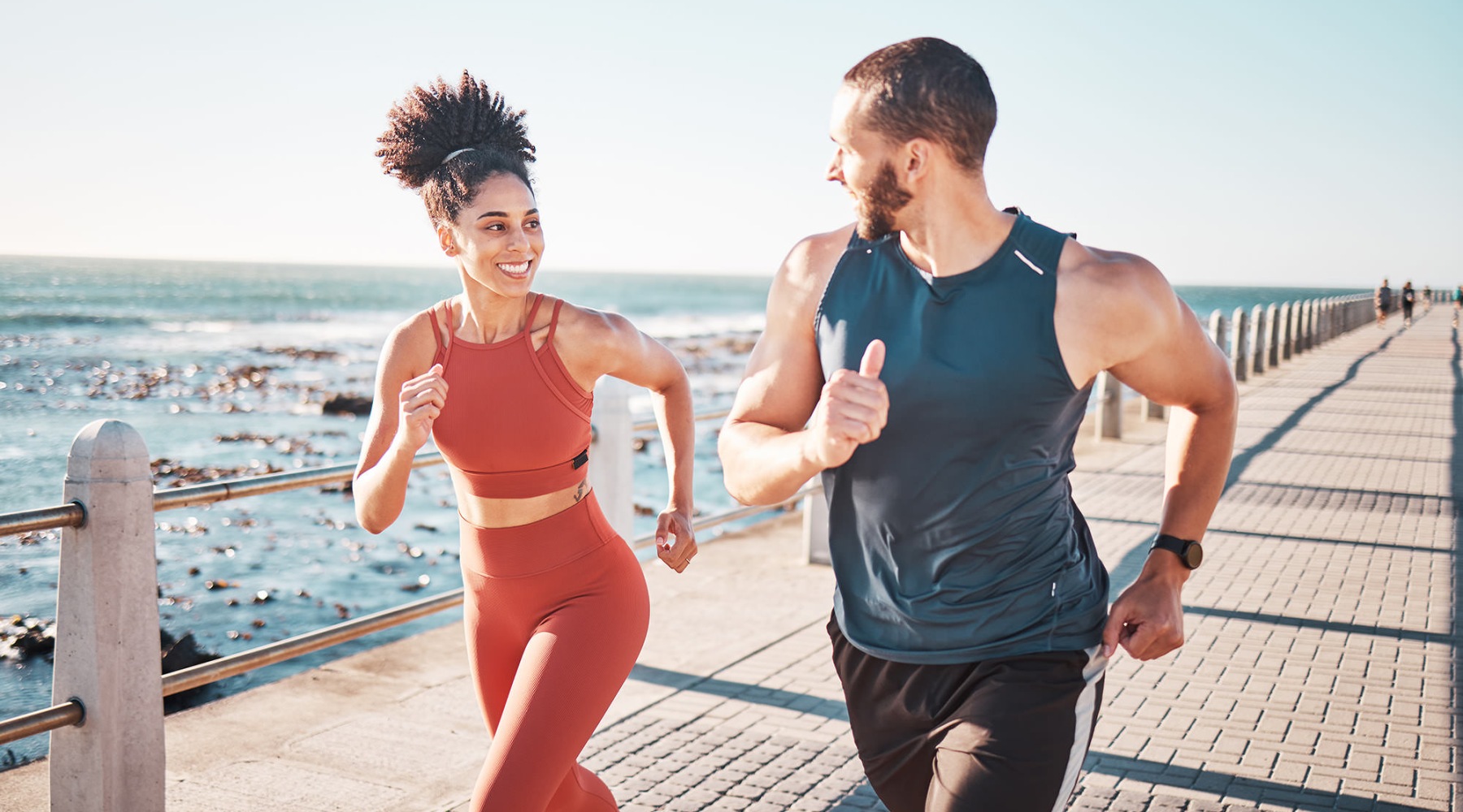 man and woman running along a beach